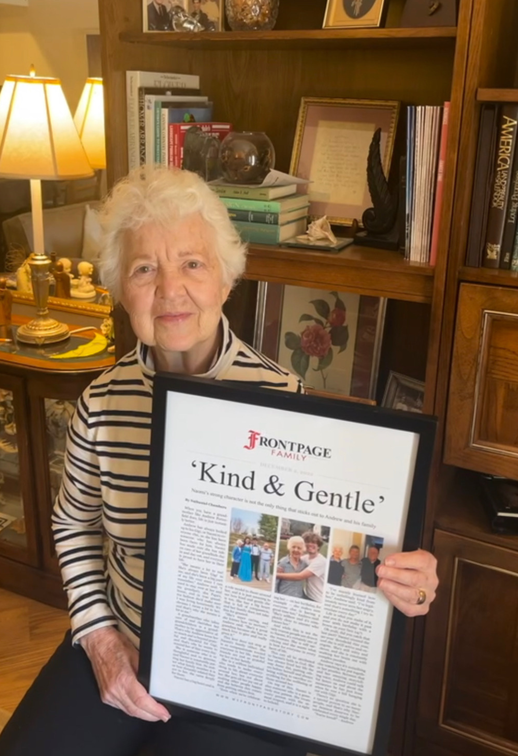 a woman holding a framed story titled 'Kind & Gentle'