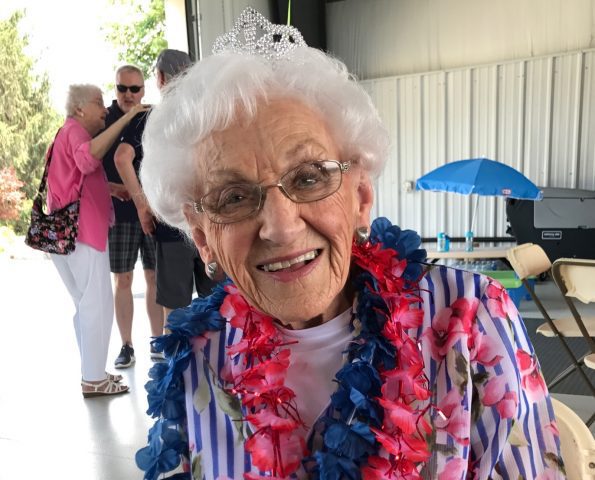 Everyone's Oma wearing her tiara and blue and pinkish red leis