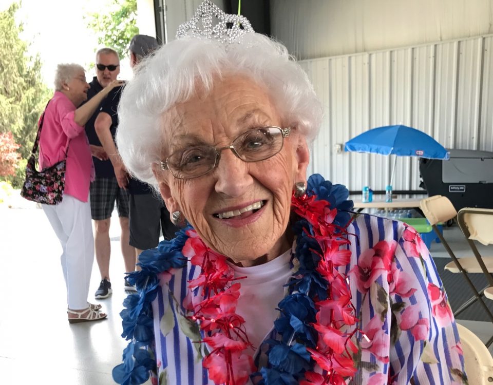 Everyone's Oma wearing her tiara and blue and pinkish red leis