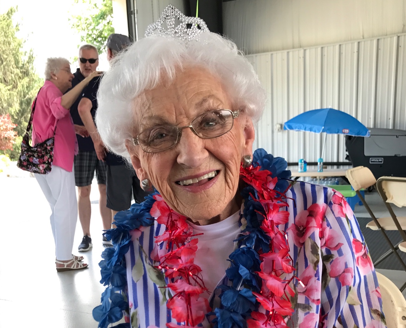 Everyone's Oma wearing her tiara and blue and pinkish red leis