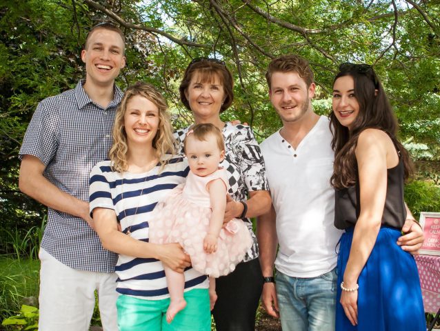 Erin Sherry with three generations of her family taking a picture together at a day party