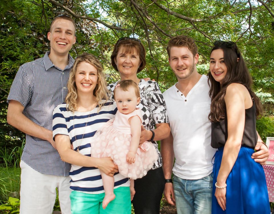 Erin Sherry with three generations of her family taking a picture together at a day party