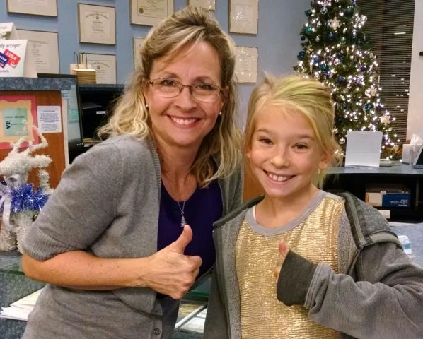 Dr. Kelley H and Kristin at the office around Christmas time in front of the Christmas tree