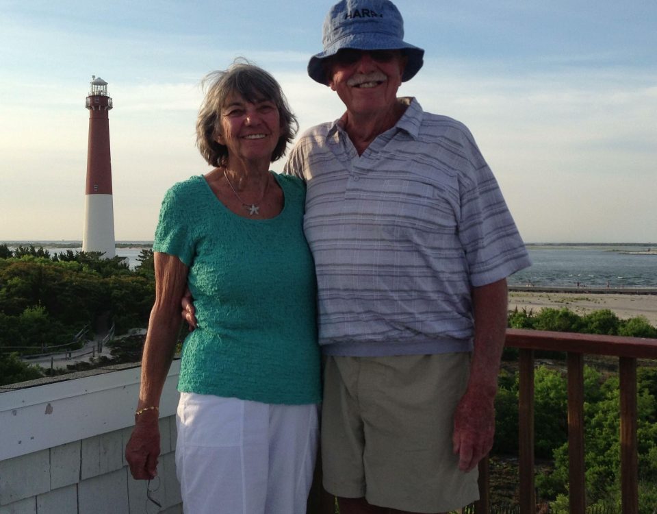 Harry and Mary smiling together in front of a lighthouse