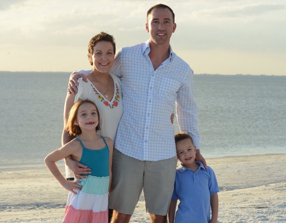 Marce Lamontagne with her husband Justin and their kids at the beach with the ocean behind them