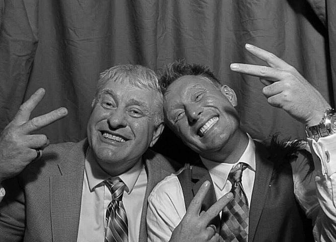 John Beckendorf and son dressed up with ties throwing up the peace sign