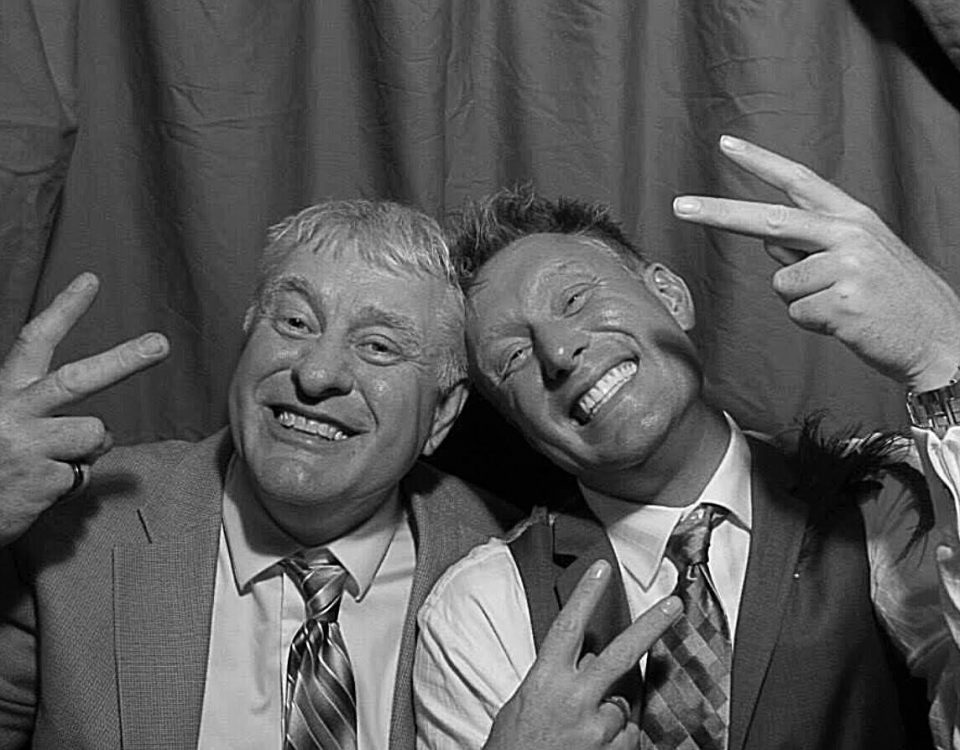 John Beckendorf and son dressed up with ties throwing up the peace sign