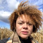 Jennifer O'Malley wearing a scarf in front of a cornfield in the fall