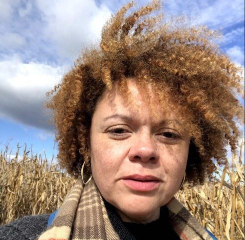 Jennifer O'Malley wearing a scarf in front of a cornfield in the fall