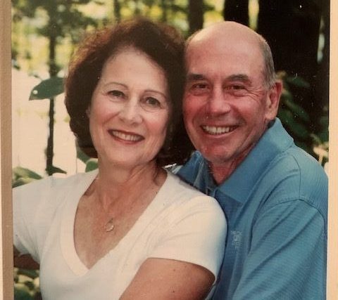 Theresan Guiney and her husband posing and smiling for a picture