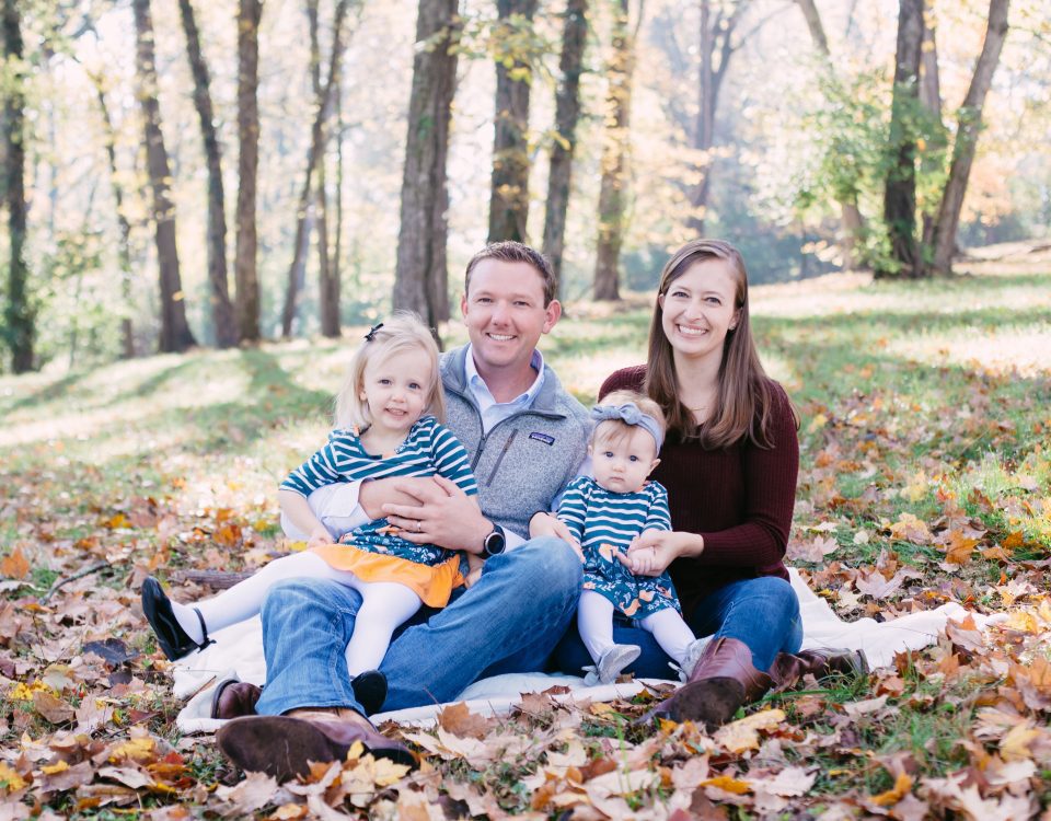 Adriana Harrington and her family with her husband and two children in the fallen leaves on the ground