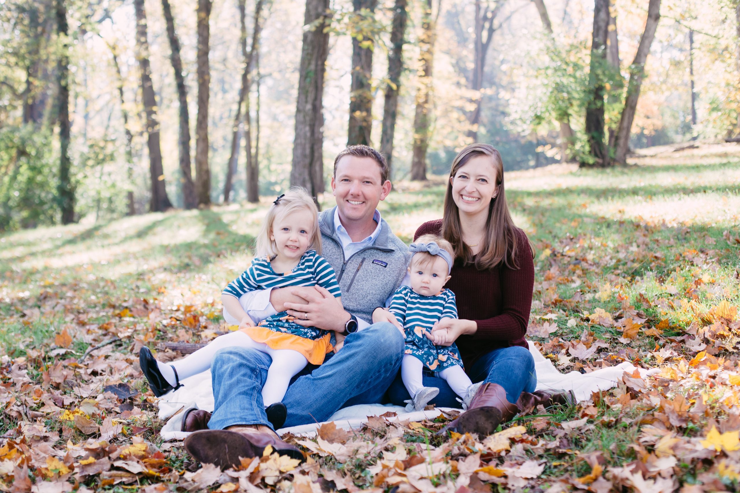 Adriana Harrington and her family with her husband and two children in the fallen leaves on the ground