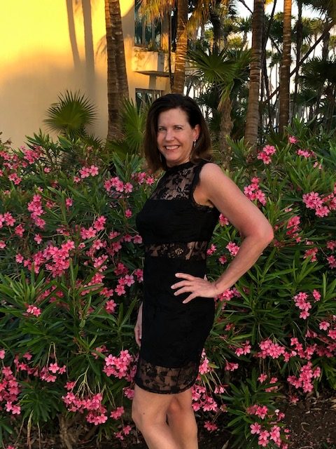 Luann Zinkel in front of a bunch of pink flowers