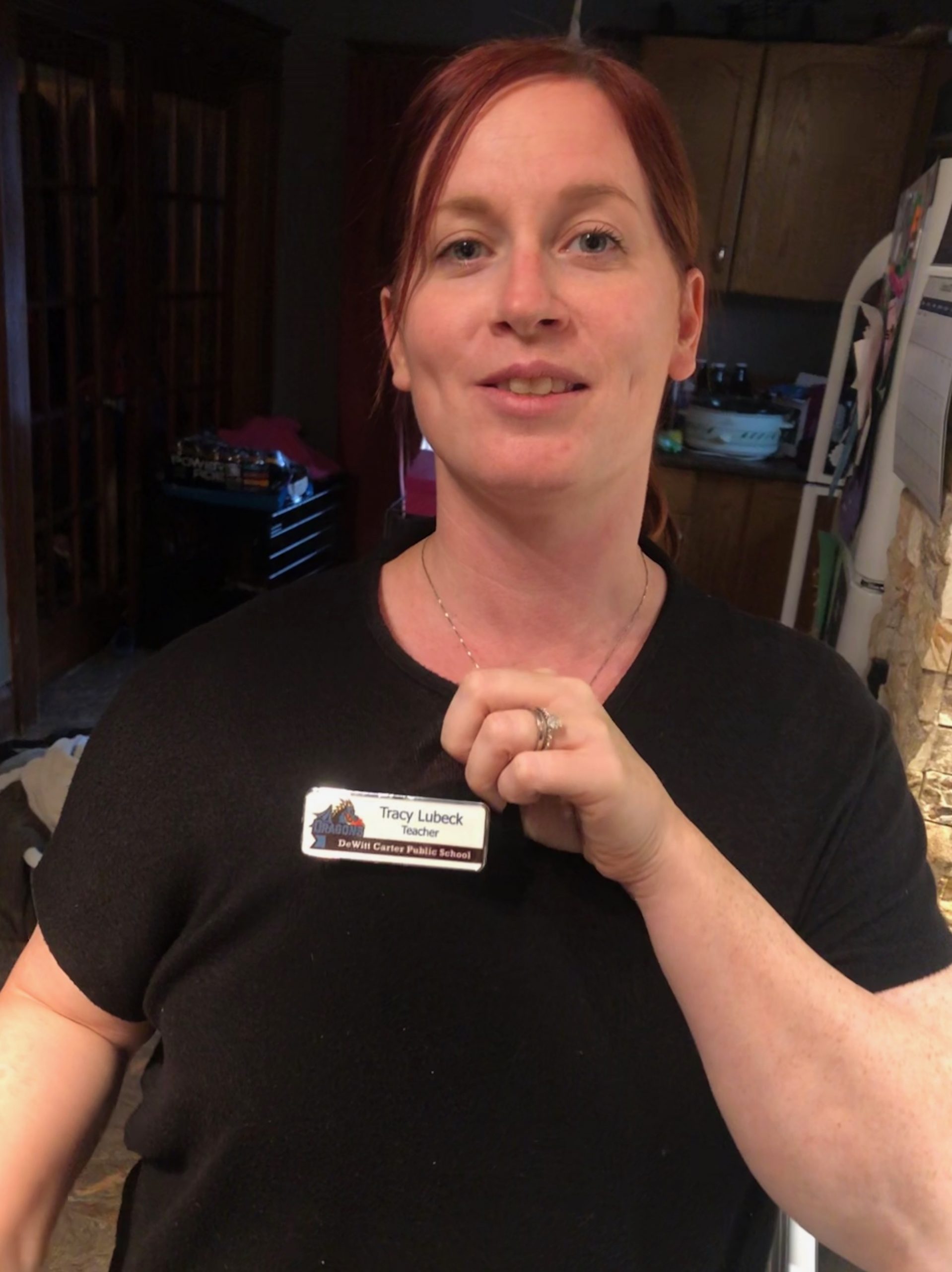 tracy lubeck wearing her teacher badge for dewitt carter public school