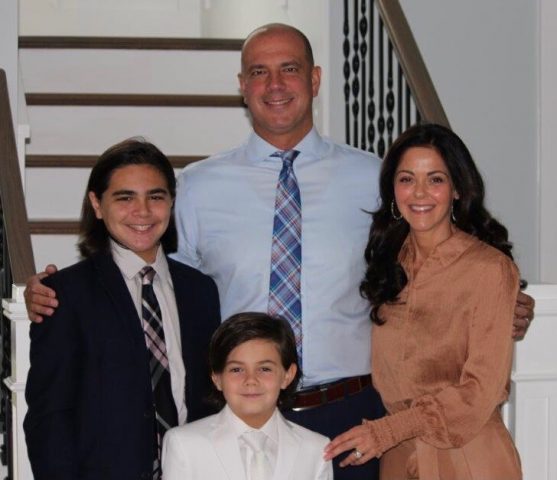 Kimberly Cooper with her husband and two sons in front of the steps