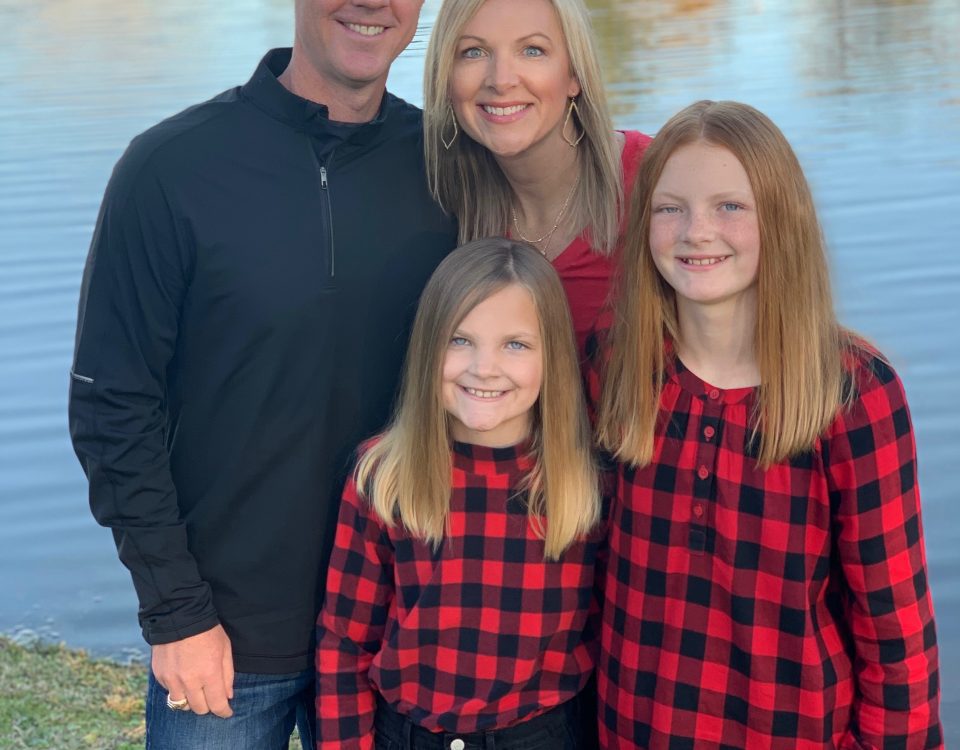 Jodi Wardinsky with her husband and daughters who are wearing matching checkered flannels