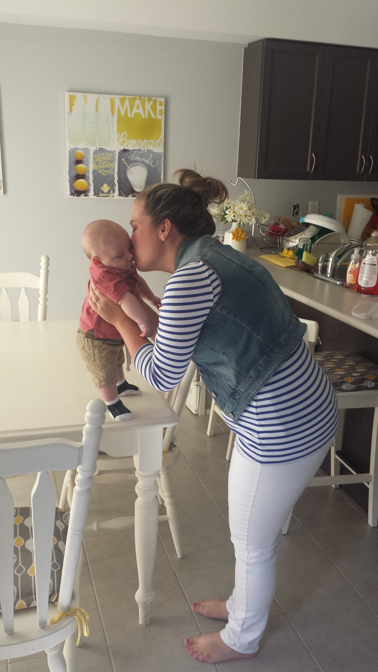 Shannon holding and kissing Mac on the cheek in the dining room