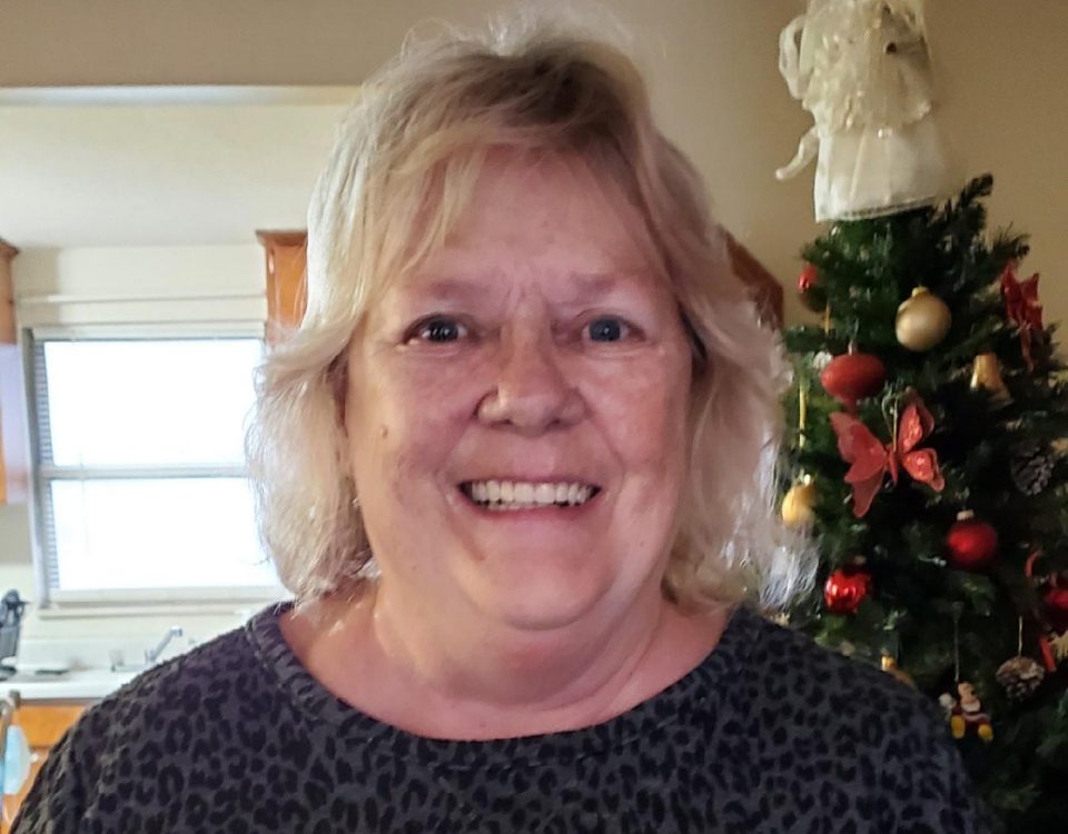 helen yarbrough smiling wide in front of the christmas tree