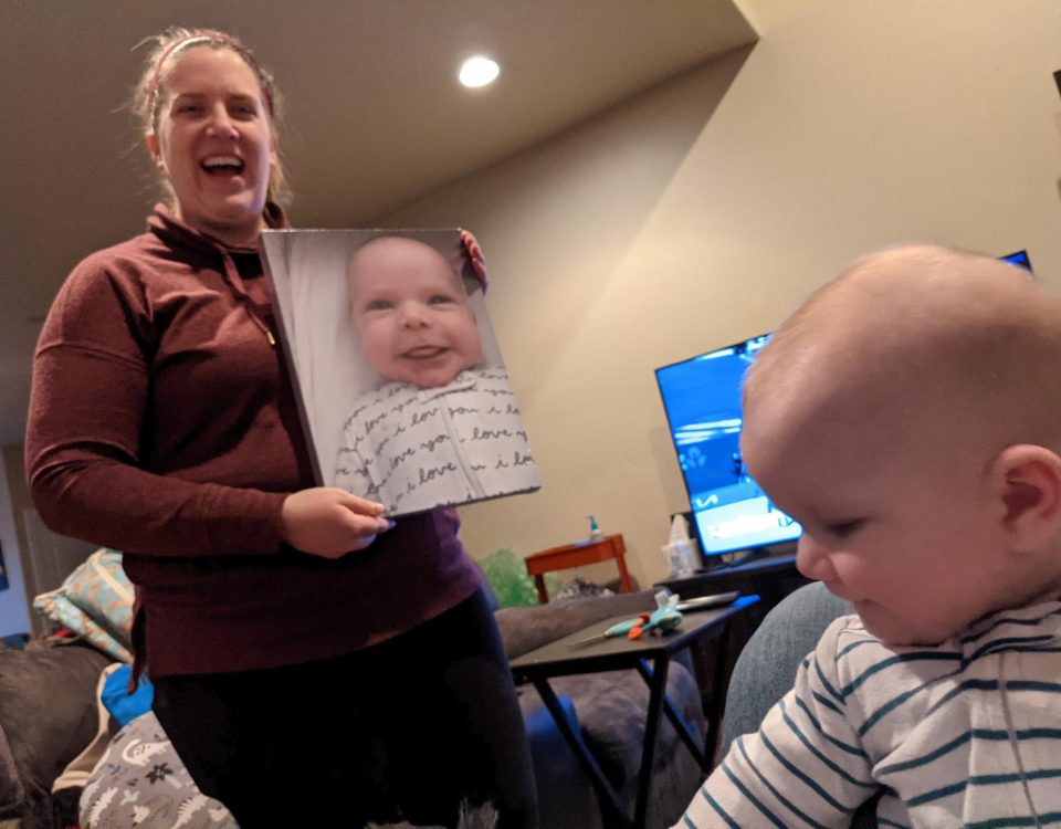 Kelsey Dallas showing her baby boy a portrait of him sticking out his tongue