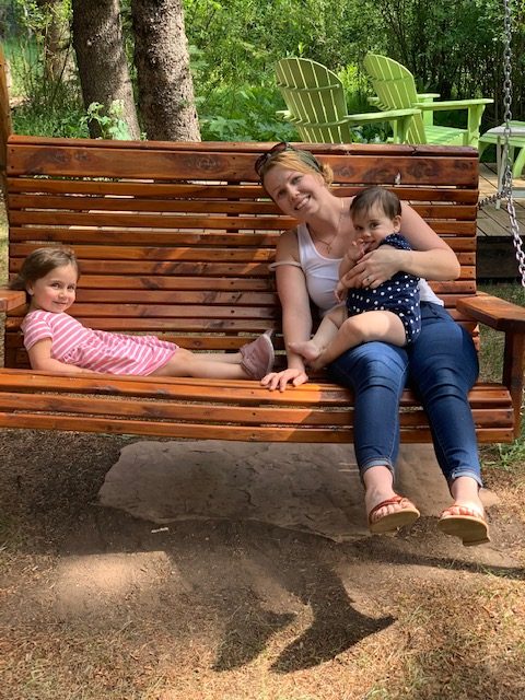 brenda west sitting with her kids on a swinging park bench