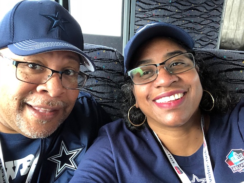 Stephanie Dixon and Bruce wearing their Dallas Cowboys gear on the bus