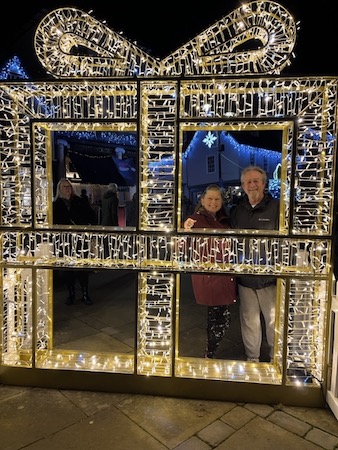 Jodie and Michael Pish hanging out behind a displayed Christmas light present