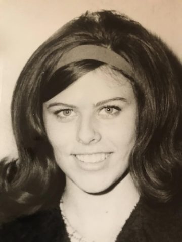 Helen Guidi smiling with a headband holding her hair back in sepia