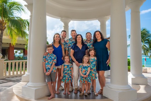 Tammy Bien and her family hanging out by the pillars by the water with palm trees