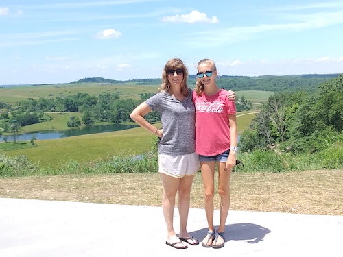 Beth Bellamah with her daughter Noelle in front of greenery