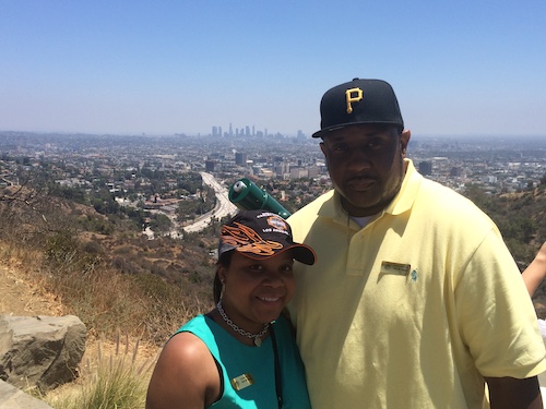 Bill King and Domonique hanging out in the mountains with a cityscape in the background