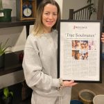 a woman holding a framed newspaper story titled 'True Soulmates'