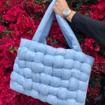 custom baby blue crochet bag held in front of a red leaf tree