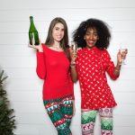 friends celebrating Christmas in matching clothes and drinking