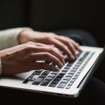 human typing on a MacBook laptop