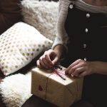 woman opening brown wrapped gift